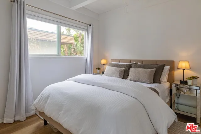 a bed sitting in a bedroom next to a window