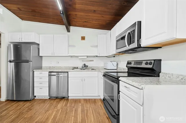 a kitchen with stainless steel appliances granite countertop a refrigerator and a stove top oven