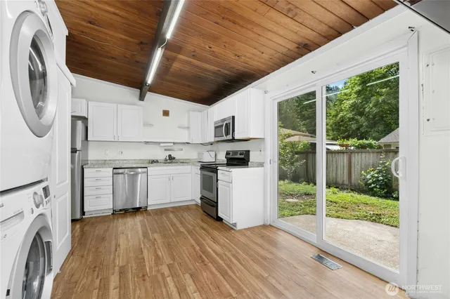 a kitchen with a refrigerator a stove top oven a sink and a large window