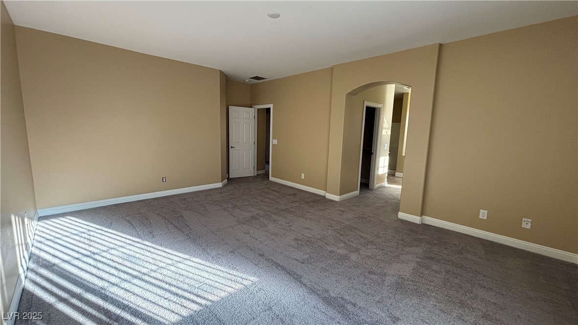 9473 Alma Ridge Avenue Las Vegas, NV 89178 - Photo 26 of 35 Carpeted spare room featuring arched walkways and baseboards