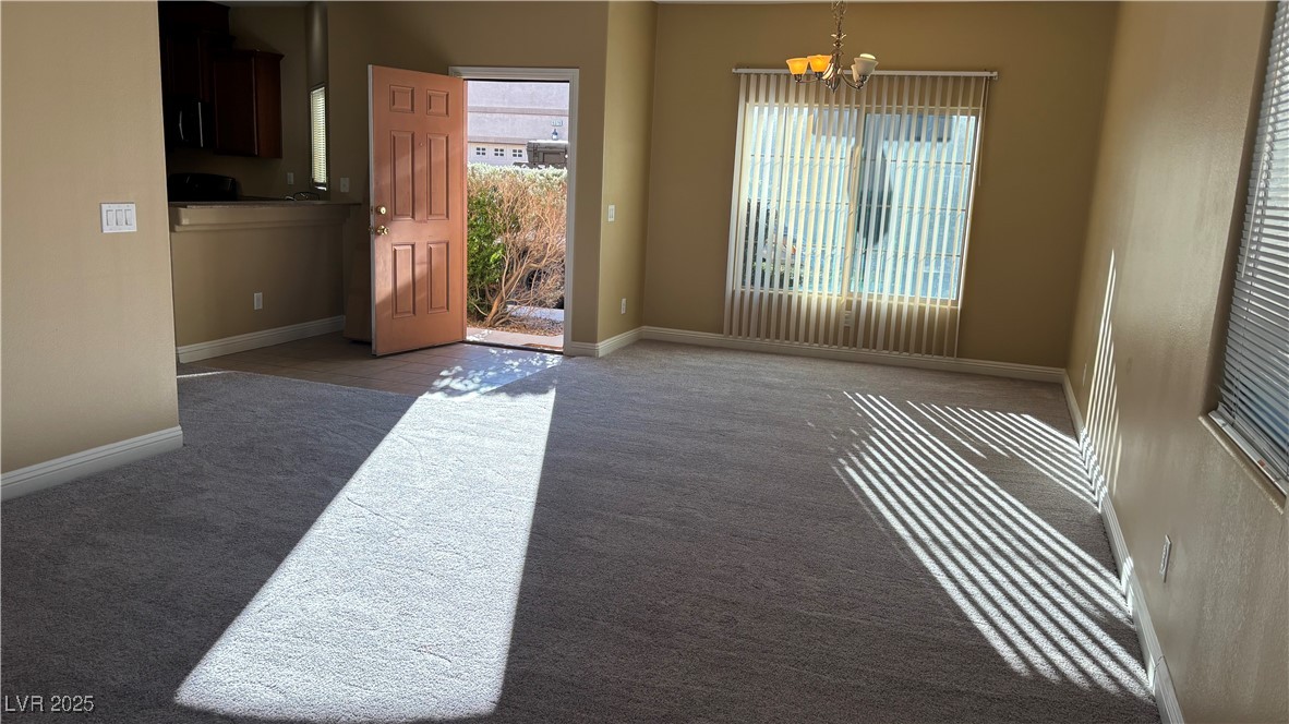 9473 Alma Ridge Avenue Las Vegas, NV 89178 - Photo 3 of 35 Carpeted empty room featuring baseboards and a chandelier