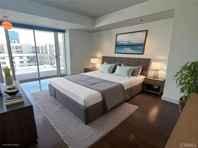 a bedroom with a bed a couch and large window