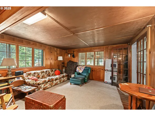 a living room with furniture a large window and potted plants