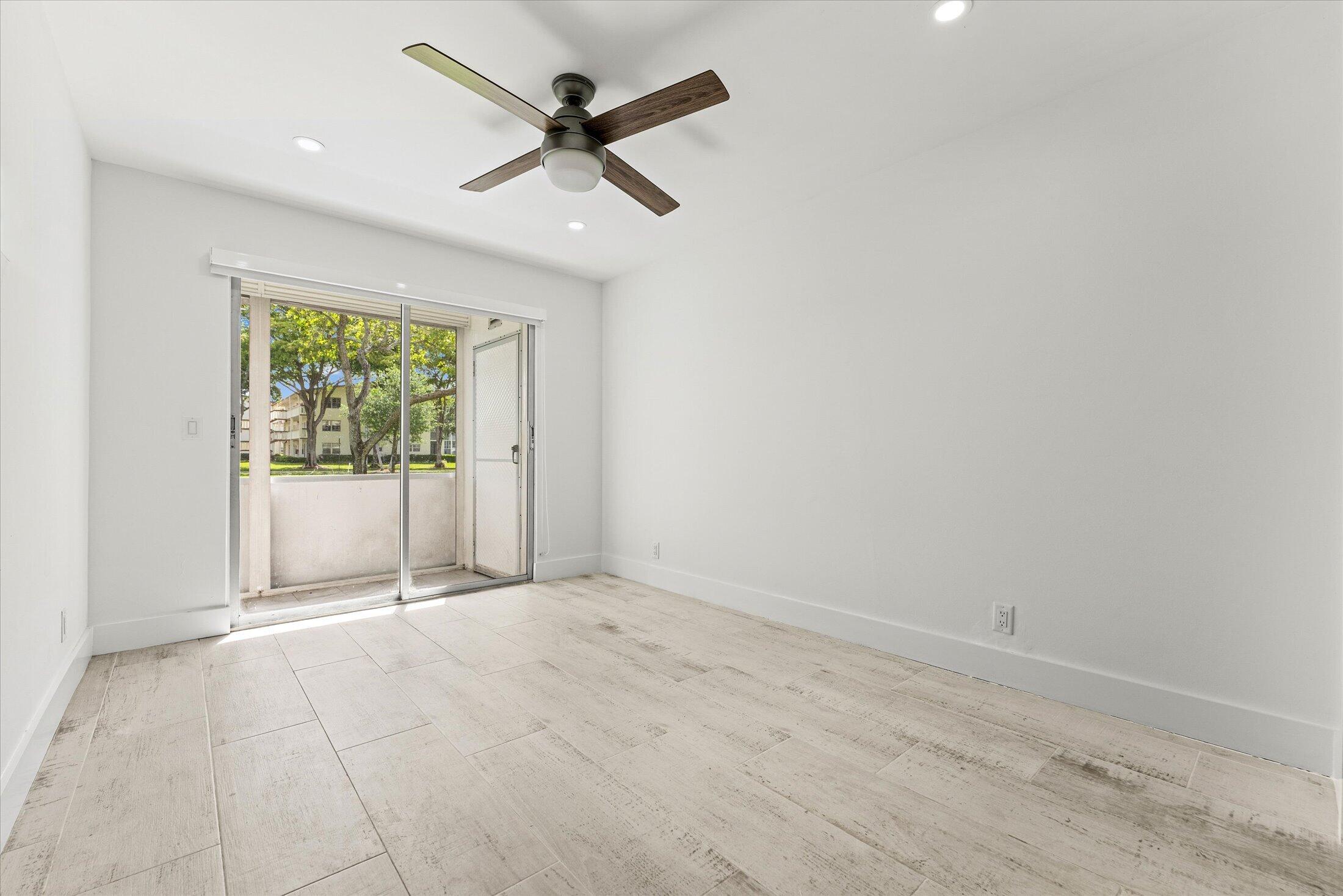 308 Preston H, Unit 308 Boca Raton, FL 33434 - Photo 13 of 22 an empty room with a ceiling fan and windows