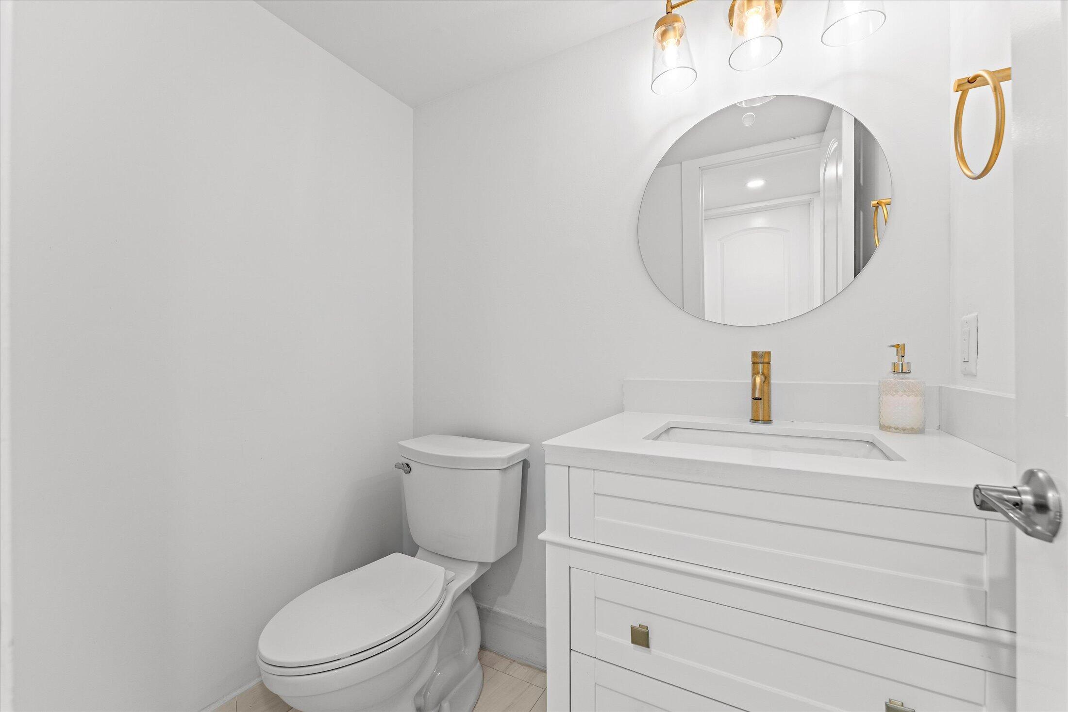 308 Preston H, Unit 308 Boca Raton, FL 33434 - Photo 18 of 22 a bathroom with a toilet a sink and mirror