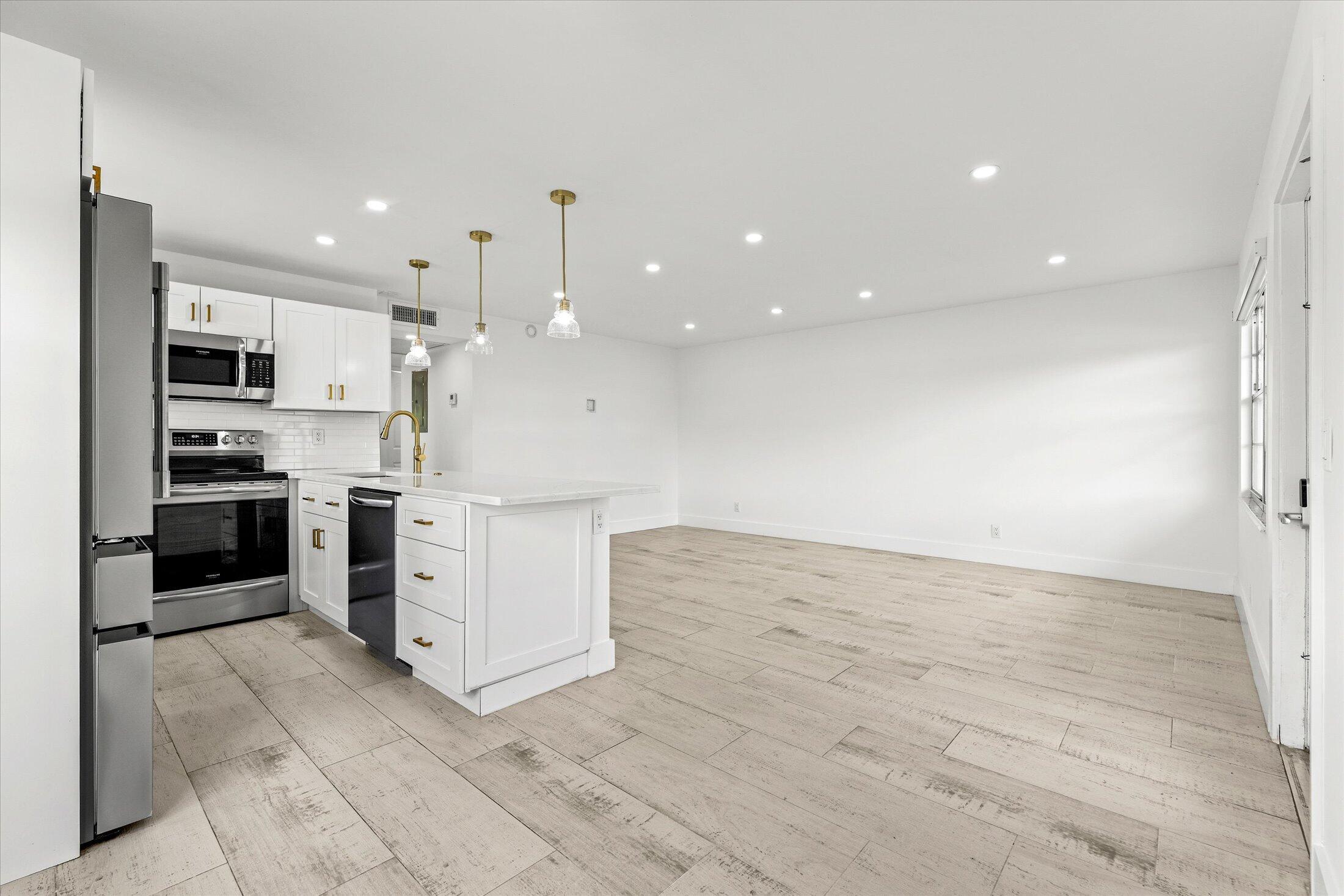 308 Preston H, Unit 308 Boca Raton, FL 33434 - Photo 6 of 22 a kitchen with stainless steel appliances kitchen island granite countertop a stove a sink and a refrigerator