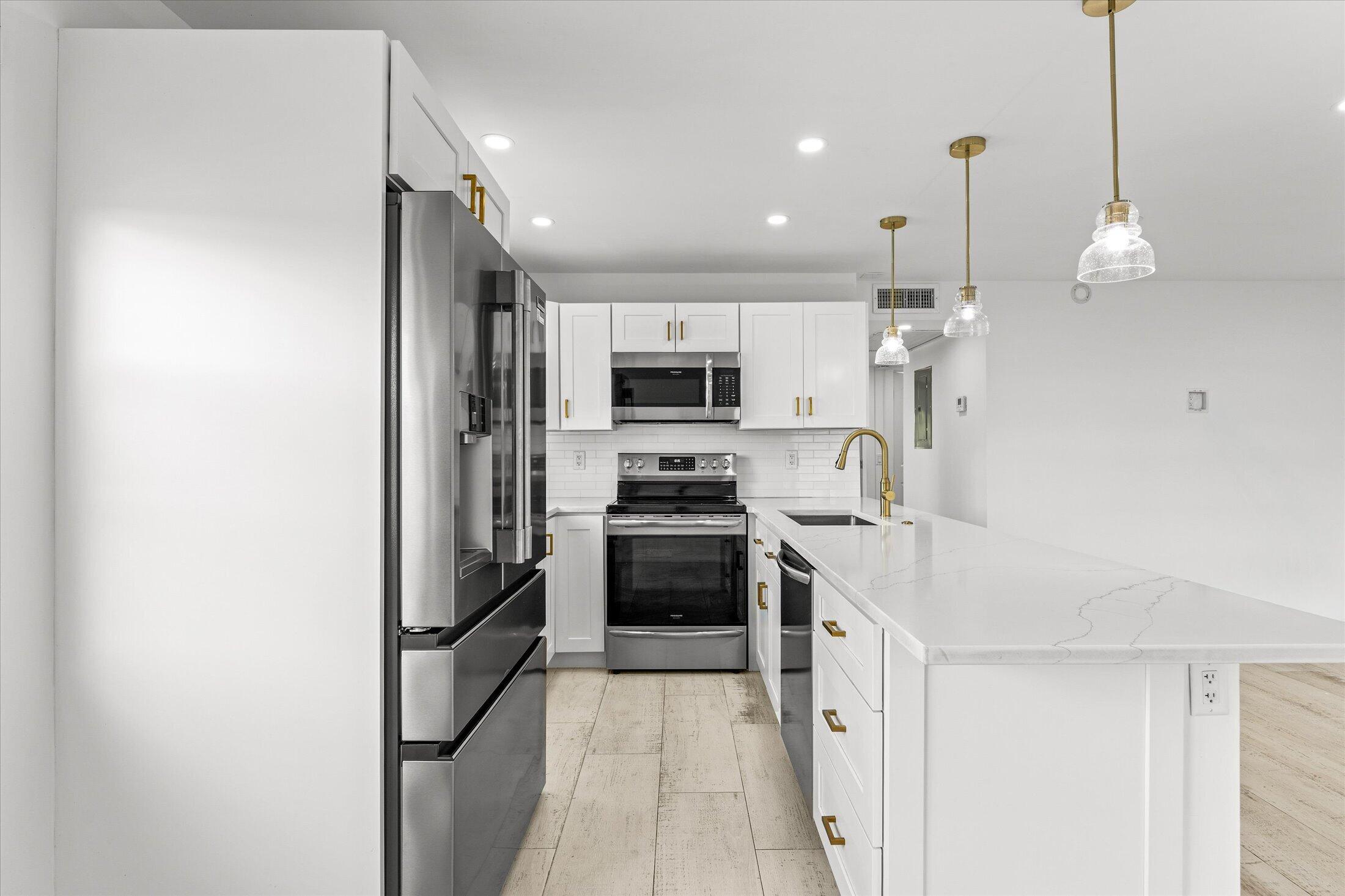 308 Preston H, Unit 308 Boca Raton, FL 33434 - Photo 7 of 22 a open kitchen with a sink and stainless steel appliances