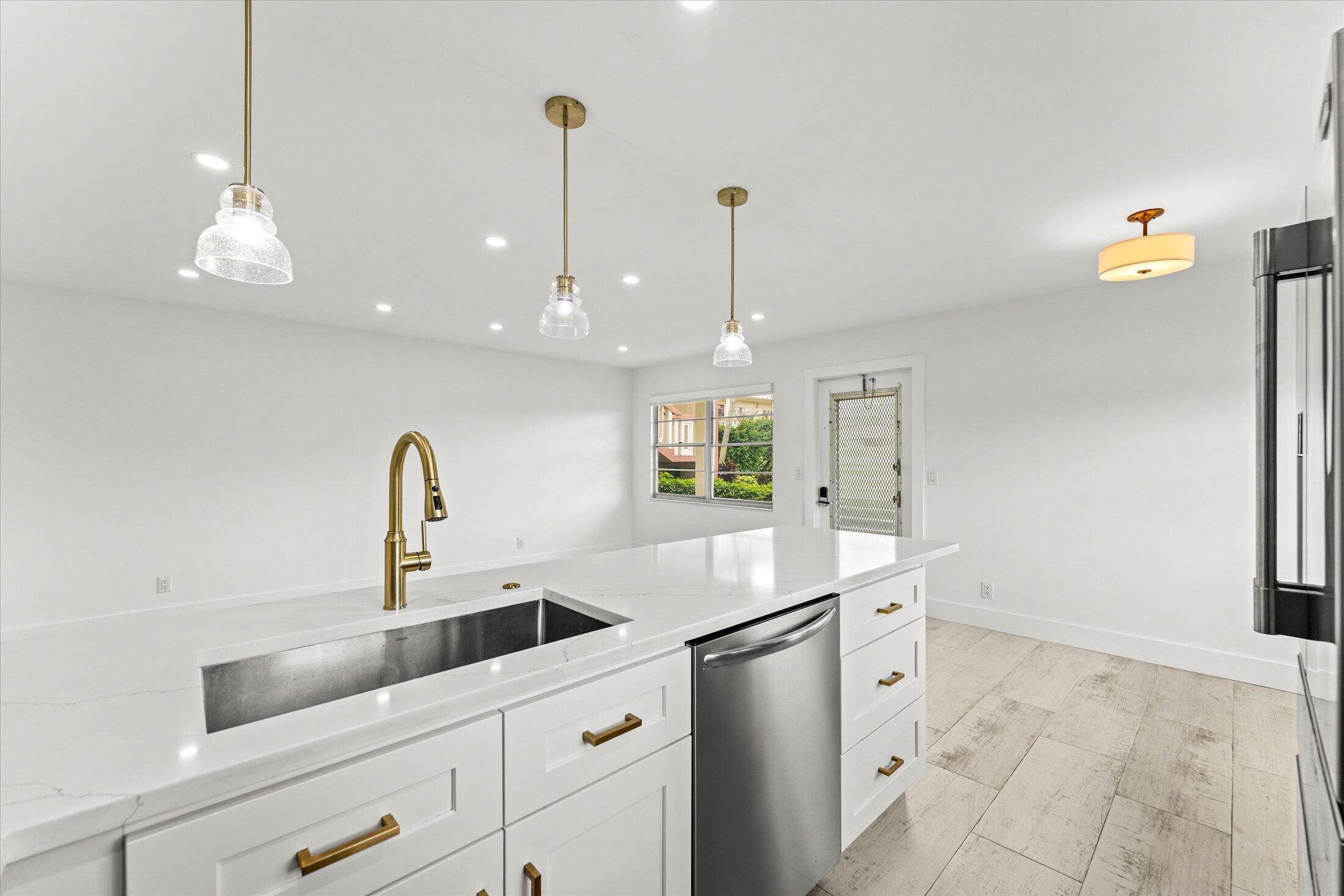 308 Preston H, Unit 308 Boca Raton, FL 33434 - Photo 8 of 22 a kitchen with a sink a counter space appliances and cabinets