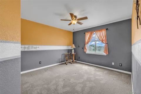 a bedroom with a bed and a ceiling fan