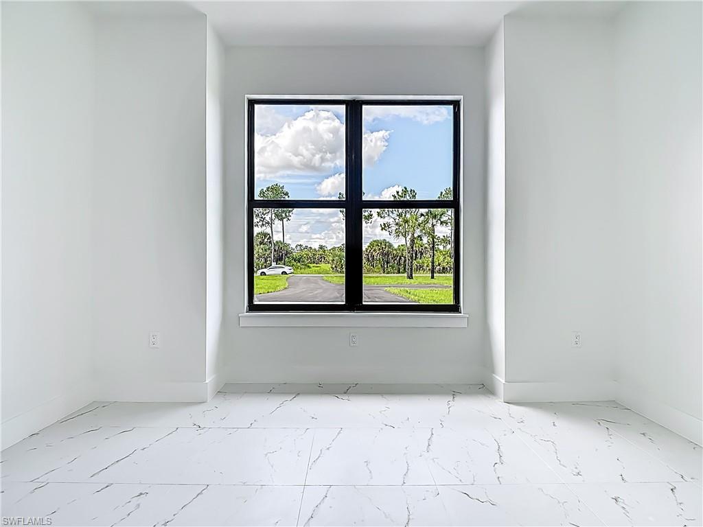 2707 36th Avenue Southeast Naples, FL 34117 - Photo 26 of 50 Spare room featuring marble finish flooring and healthy amount of natural light