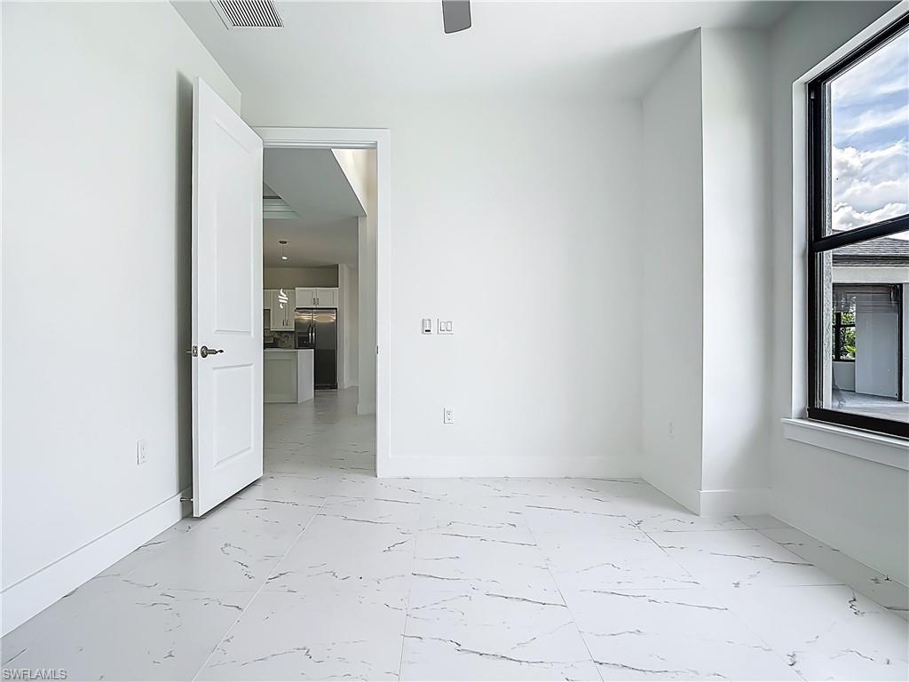 2707 36th Avenue Southeast Naples, FL 34117 - Photo 27 of 50 Empty room with light marble finish floors and baseboards