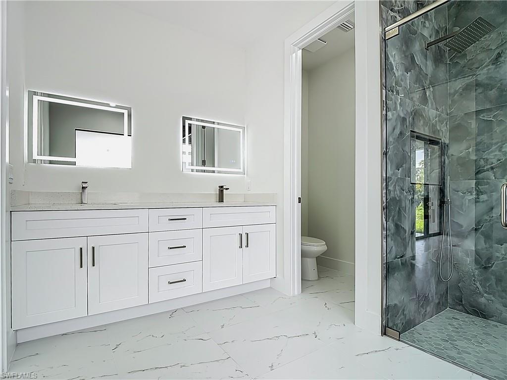 2707 36th Avenue Southeast Naples, FL 34117 - Photo 32 of 50 Full bath with marble finish flooring, a marble finish shower, and double vanity