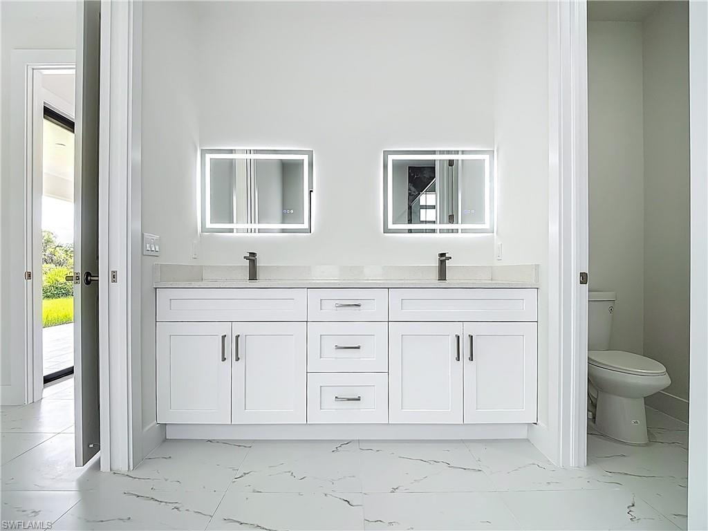 2707 36th Avenue Southeast Naples, FL 34117 - Photo 33 of 50 Bathroom featuring marble look tiles and double vanity