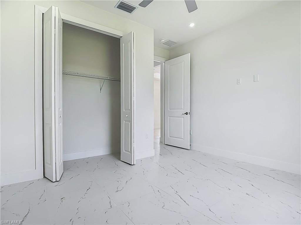 2707 36th Avenue Southeast Naples, FL 34117 - Photo 35 of 50 Unfurnished bedroom featuring marble look tiles, a closet, recessed lighting, and ceiling fan