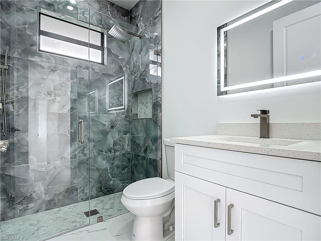 2707 36th Avenue Southeast Naples, FL 34117 - Photo 39 of 50 Bathroom with vanity, marble finish flooring, and a marble finish shower
