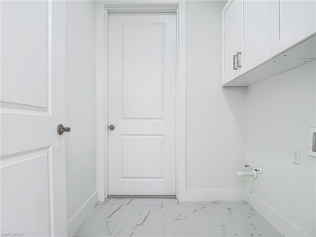 2707 36th Avenue Southeast Naples, FL 34117 - Photo 40 of 50 Laundry area featuring cabinet space, light marble finish flooring, hookup for a washing machine, and gas dryer hookup