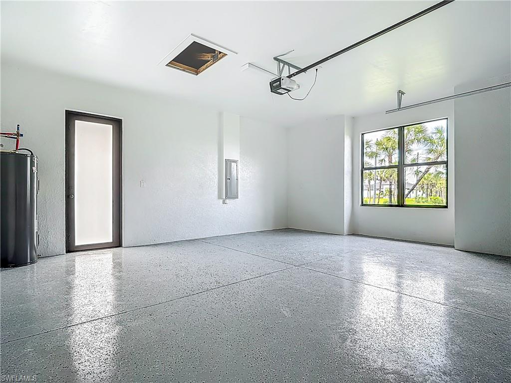 2707 36th Avenue Southeast Naples, FL 34117 - Photo 43 of 50 Garage with water heater, electric panel, and a garage door opener