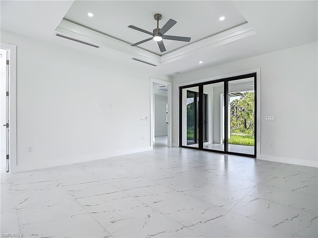 2707 36th Avenue Southeast Naples, FL 34117 - Photo 8 of 50 Empty room featuring a raised ceiling, marble look tile flooring, ceiling fan, and recessed lighting