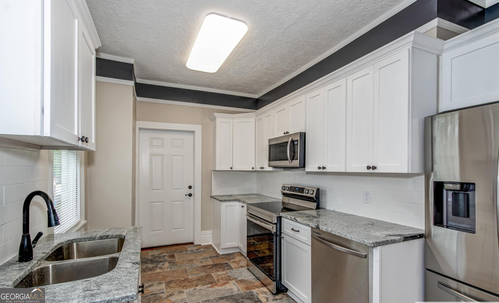 136 Broad Street Augusta, GA 30901 - Photo 6 of 8 a kitchen with stainless steel appliances granite countertop a sink stove and refrigerator