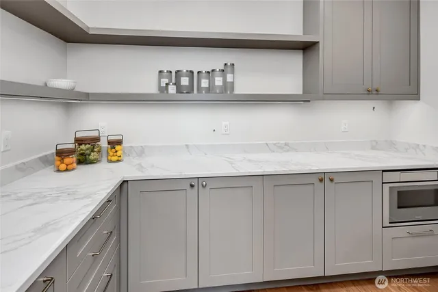 a kitchen with white cabinets and a wooden floor