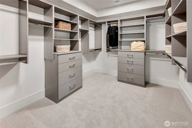 a view of walk in closet with clothes and shoes