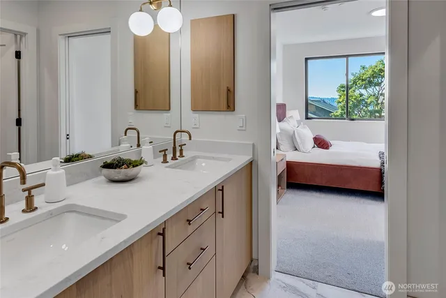 a en suite bathroom with 2 sink tub and a mirror