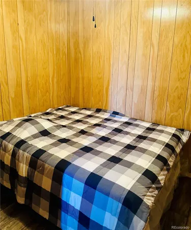 a bed sitting in a bedroom next to a curtain and a curtain