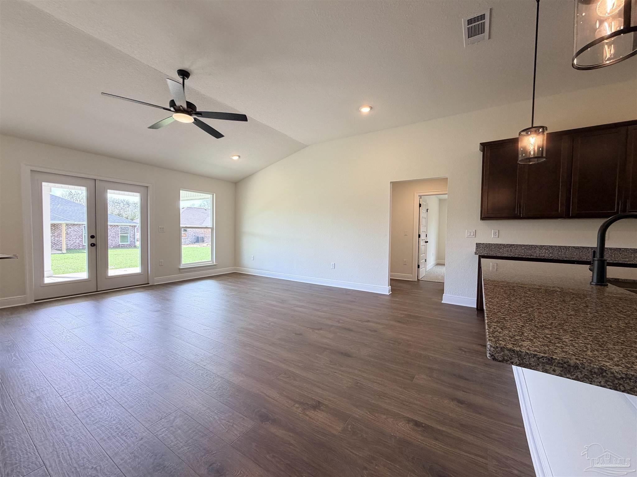 5263 Wahoo Road Milton, FL 32583 - Photo 11 of 25 a view of a livingroom with wooden floor and a ceiling fan