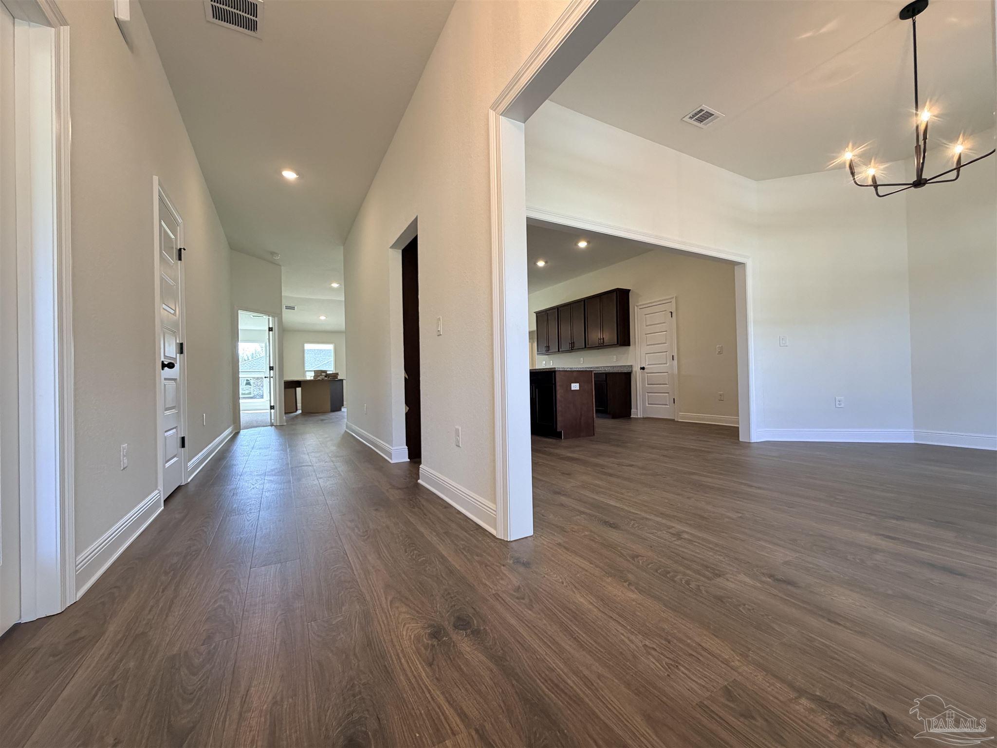 5263 Wahoo Road Milton, FL 32583 - Photo 4 of 25 a view of a big room with wooden floor and a kitchen