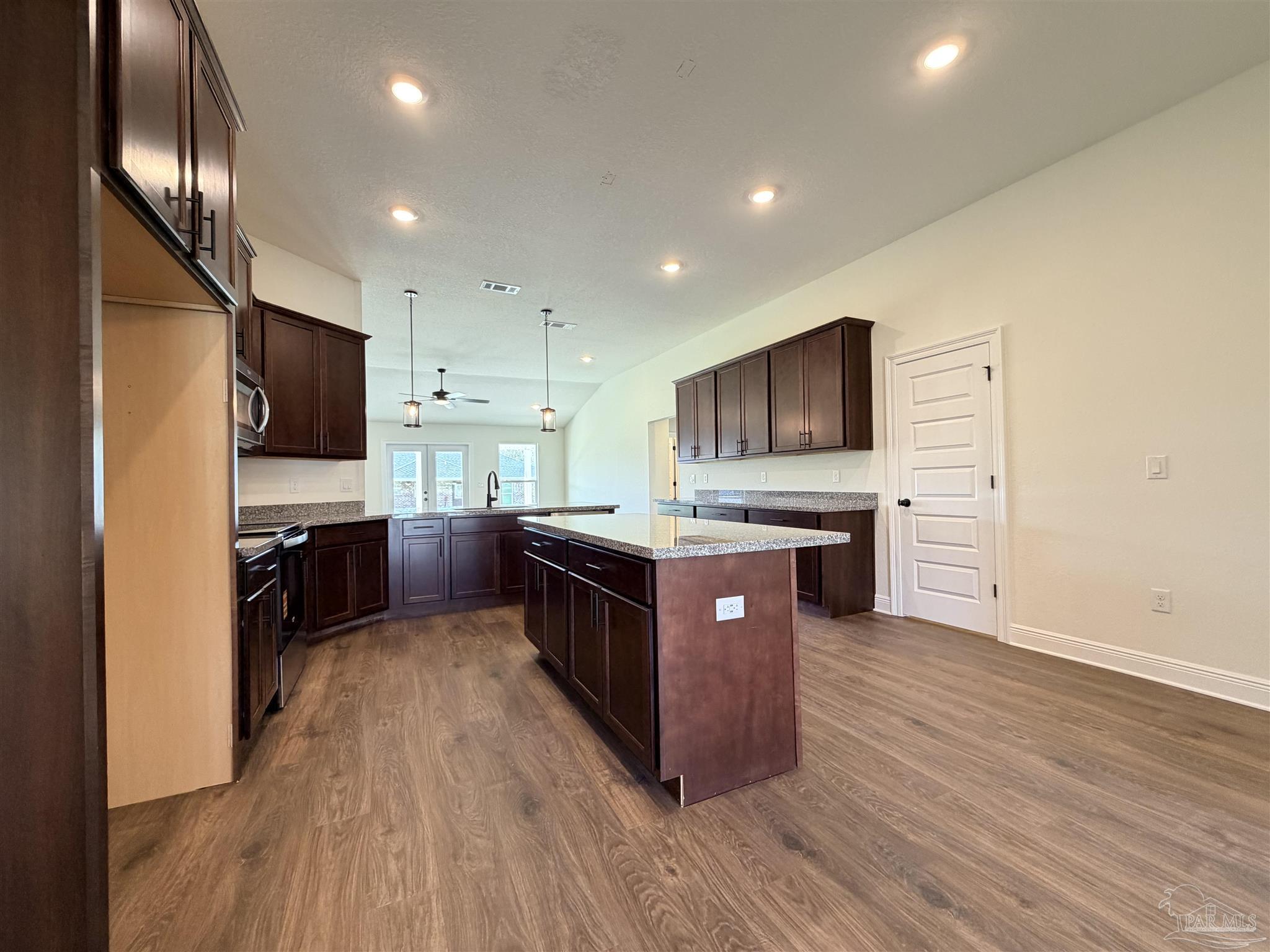 5263 Wahoo Road Milton, FL 32583 - Photo 7 of 25 a large kitchen with stainless steel appliances and a stove top oven