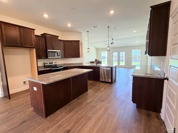 a large kitchen with stainless steel appliances and wooden cabinets