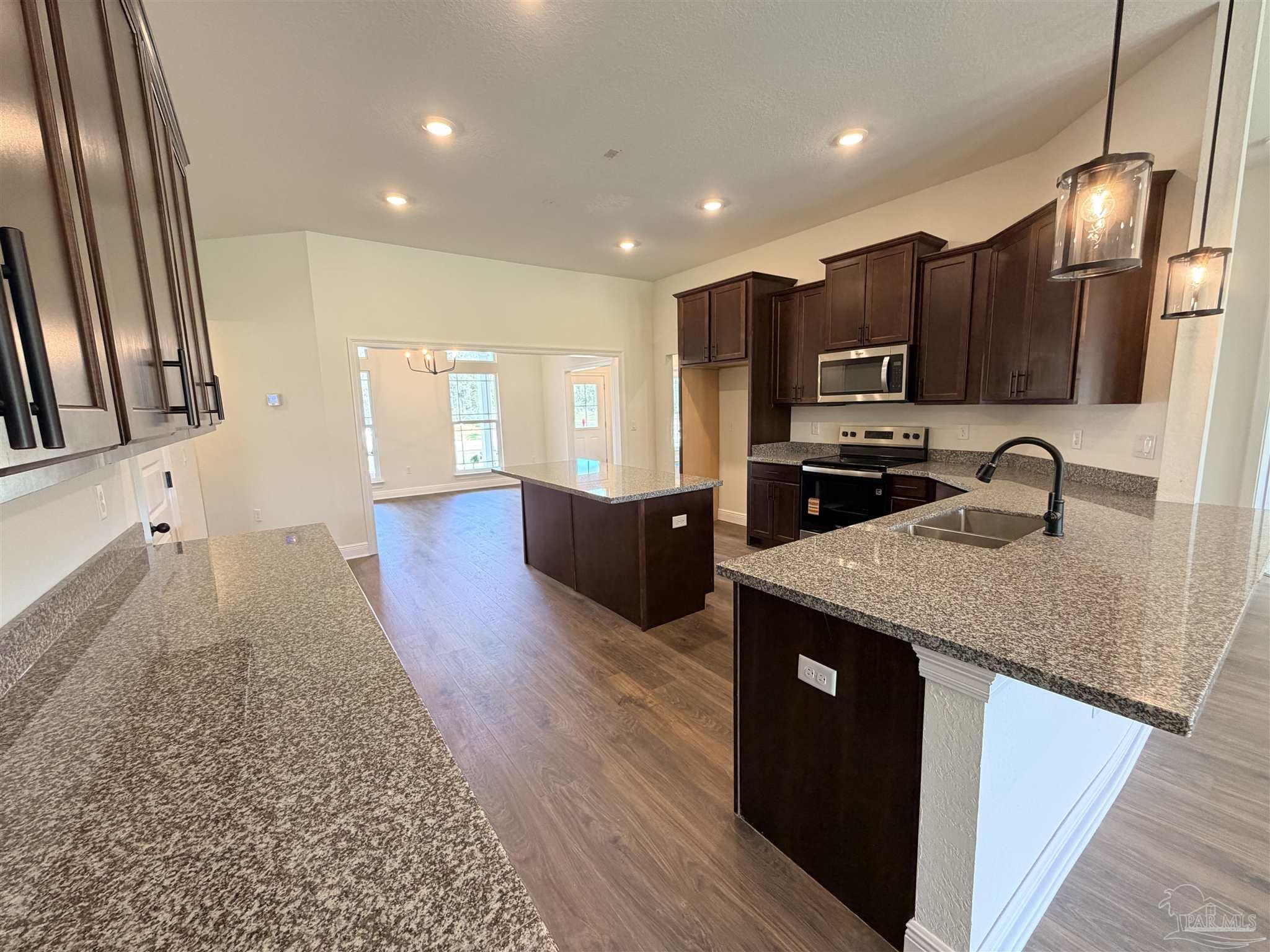 5263 Wahoo Road Milton, FL 32583 - Photo 9 of 25 a kitchen with stainless steel appliances granite countertop a sink stove and refrigerator