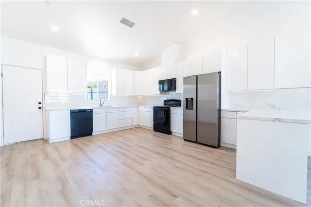 a kitchen with a refrigerator sink and cabinets