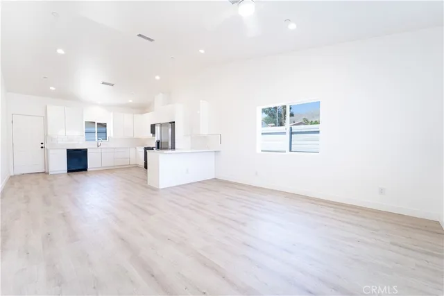 a view of a kitchen with furniture and wooden floor