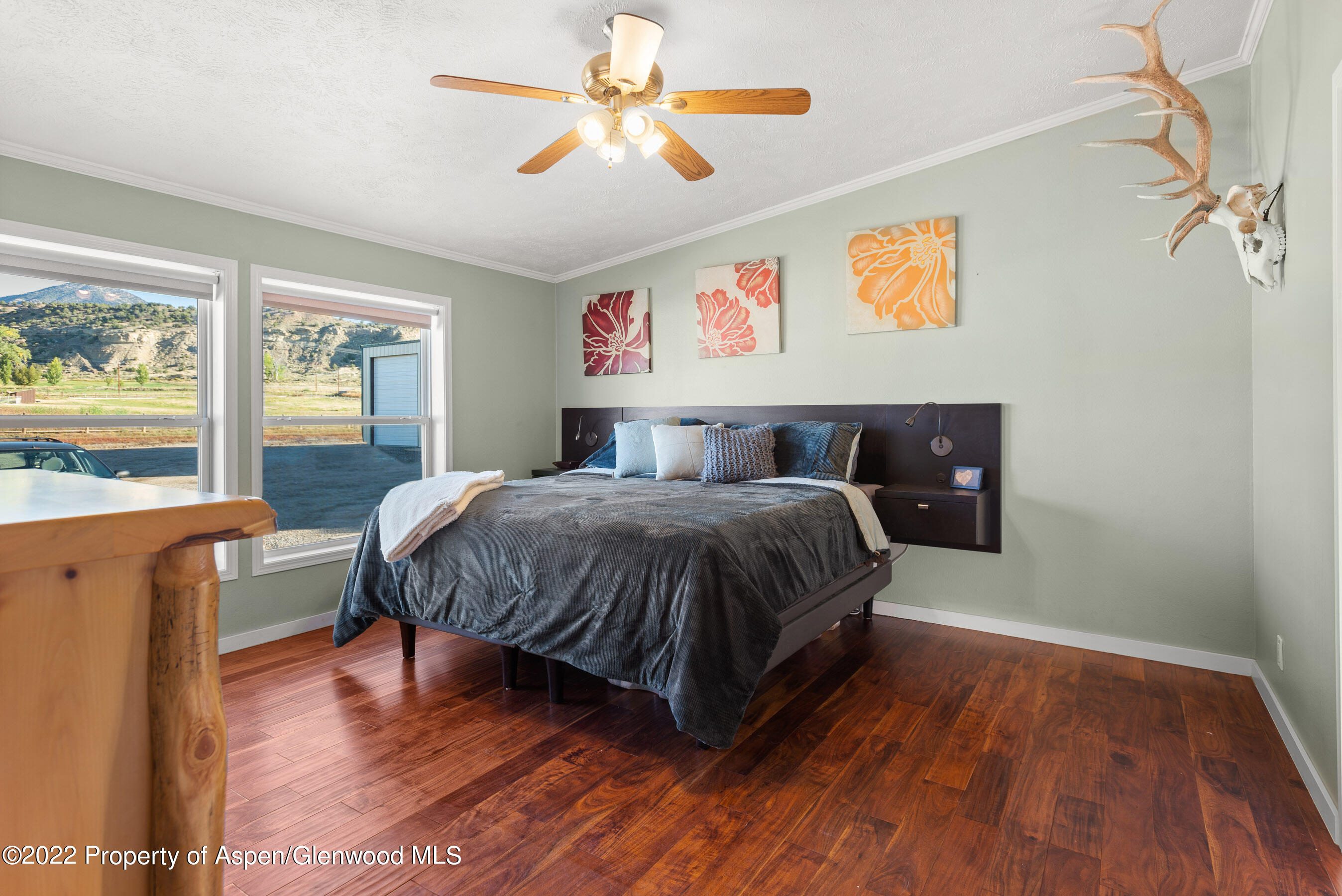 130 Swiss Lane Road Rifle, CO 81650 - Photo 12 of 39 a bedroom with a large bed and a chandelier