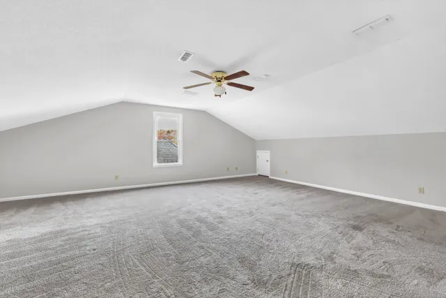 an empty room with a ceiling fan and a window