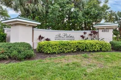 a view of a sign in a yard with potted plants