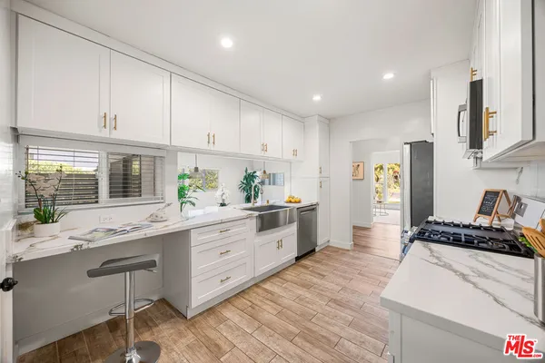 a kitchen with stainless steel appliances granite countertop a stove a sink and a refrigerator