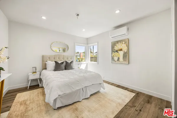 a bedroom with a bed and wooden floor
