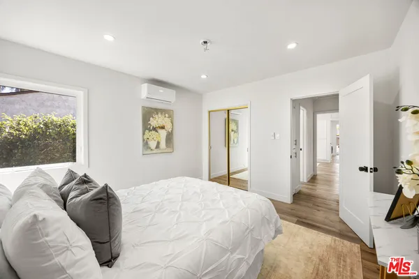 a bedroom with a bed and a large window
