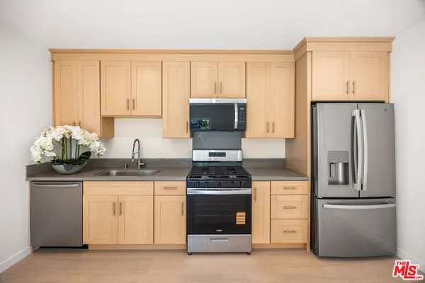 a kitchen with granite countertop a stove and a refrigerator