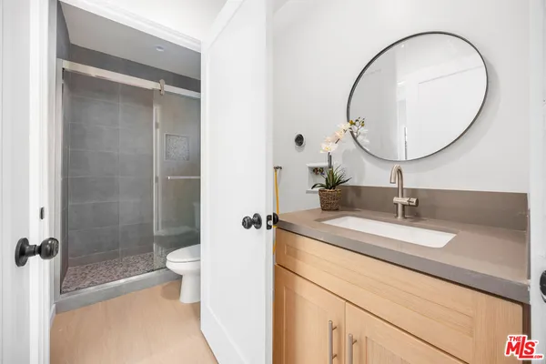 a bathroom with a sink a toilet and a mirror