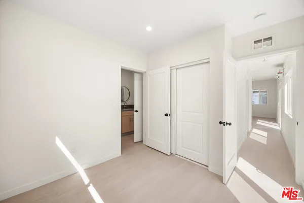 a view of a hallway with closet and bathroom