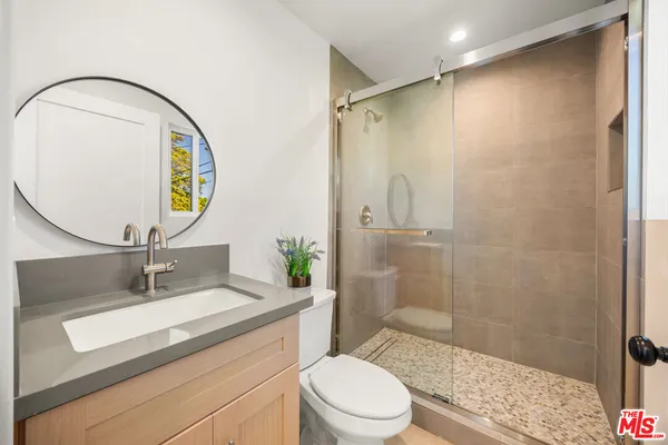 a bathroom with a sink a toilet and shower