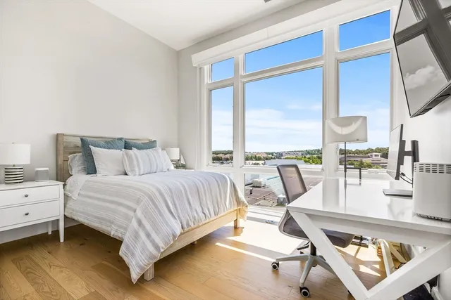 a bedroom with a bed a large window with table and chairs