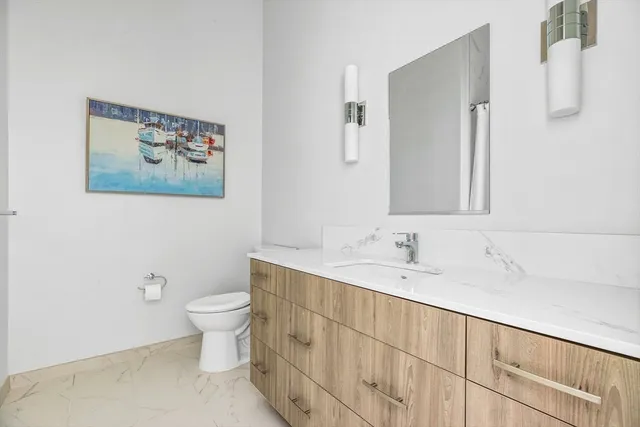 a bathroom with a toilet sink and mirror