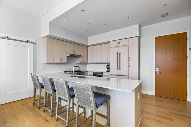 a kitchen with stainless steel appliances a table and chairs in it