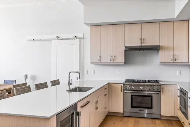 a kitchen with stainless steel appliances a stove a sink and white cabinets
