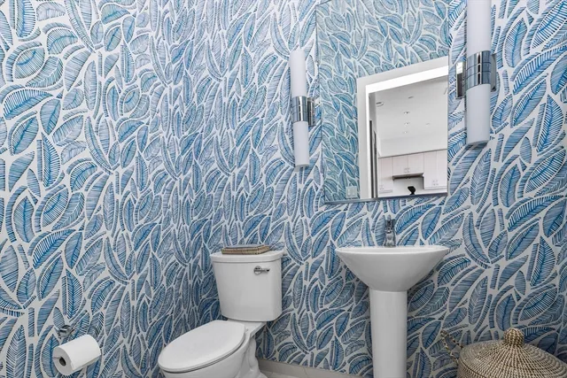 a bathroom with a toilet sink and mirror