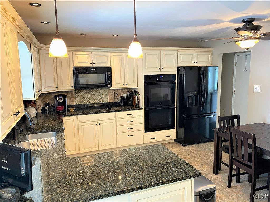 1415 Thomas Drive Coplay, PA 18037 - Photo 2 of 32 a kitchen with stainless steel appliances granite countertop a refrigerator a stove a sink a dining table and chairs with wooden floor